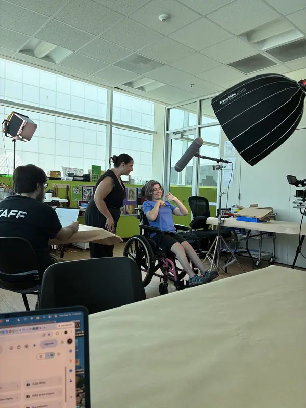 A storyteller in a wheelchair is filmed in a bright workshop room.
